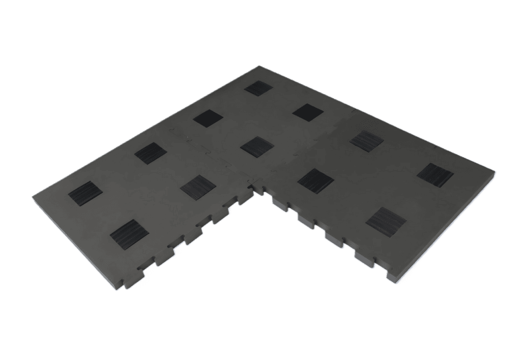 Schwarze, ineinandergreifende Bodenpaneele in L-Form mit rechteckigen Rillen auf der Oberfläche.